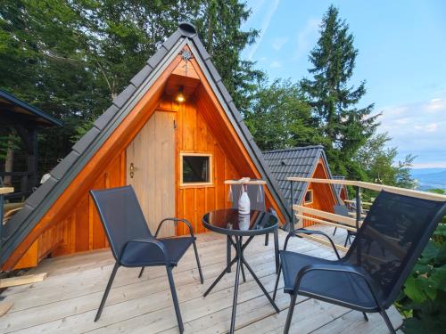 a cabin with a table and chairs on a deck at AirWood Glamping in Križe