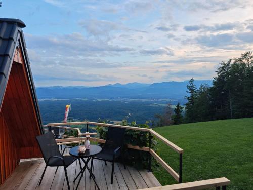 a deck with a table and chairs on a hill at AirWood Glamping in Križe