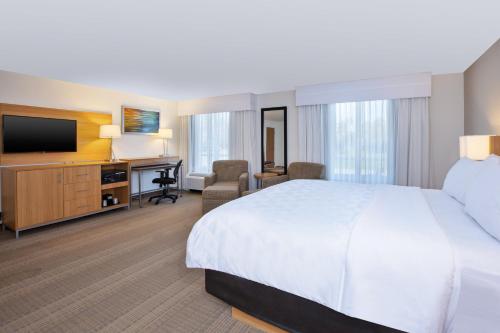 a hotel room with a bed and a desk at Holiday Inn Morgantown-University Area by IHG in Morgantown
