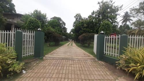 a white gate with a brick road at The Garden Resort Airport Katunayaka in Katunayake