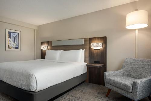 a hotel room with a bed and a chair at Holiday Inn Express Baltimore At The Stadiums by IHG in Baltimore