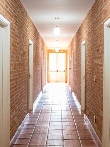 an empty hallway with a brick wall at Siloe Hotel by Concavus in Vinhedo