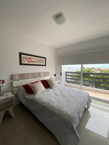 a bedroom with a bed and a large window at Mendoza Aparts - Con cochera in Villa María