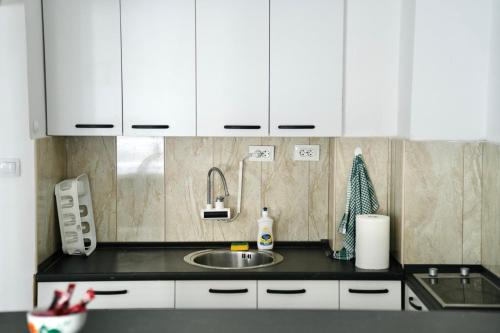 een keuken met witte kasten en een spoelbak bij Stefea Apartment in Ohrid