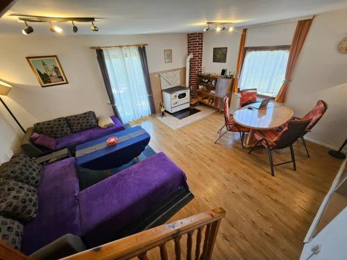 a living room with a purple couch and a table at Give Peace a Chance - 10 km from Sarajevo City Center in Petrovići