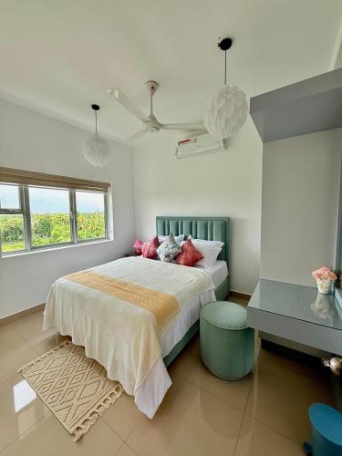 a bedroom with a bed and a ceiling fan at Zeleny Santorini in Negombo