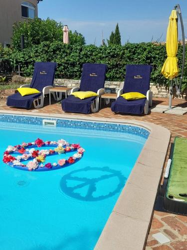a swimming pool with two lounge chairs and a swimming pool at Villa-Johanna in Kaštelir