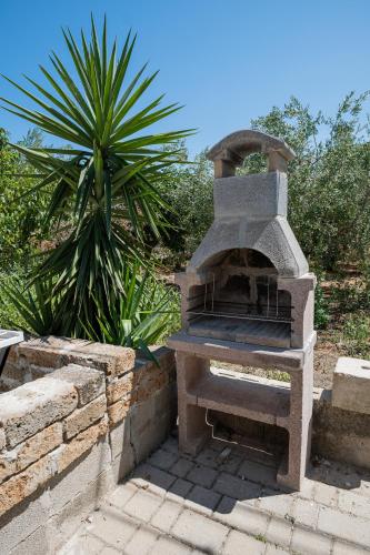 a stone oven in a garden with a palm tree at Riserva-La marea in Vasto