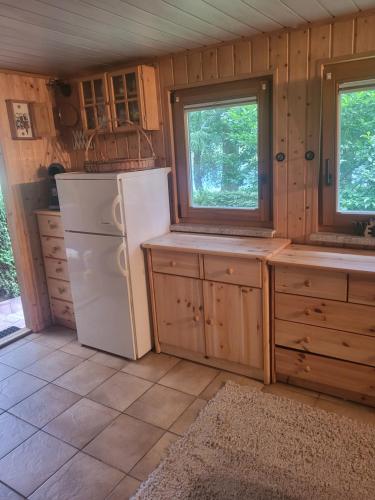a kitchen with a white refrigerator and two windows at Holzhäusl am Fuße des Liliensteins in Königstein an der Elbe