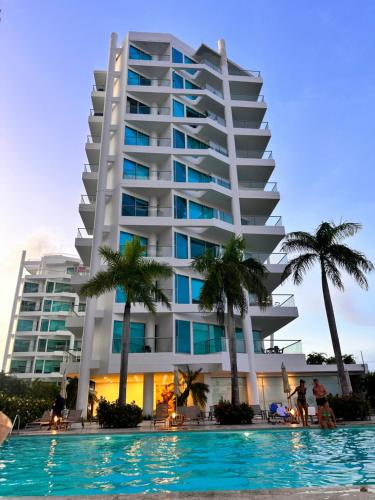 a hotel with a swimming pool in front of a building at Playa -Boquilla -Apto en Condominio in Cartagena de Indias