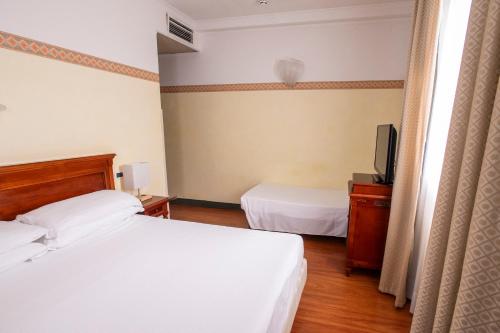 a hotel room with two beds and a television at Hotel Russo Palace in Venice-Lido