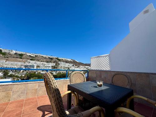 a table and chairs on a balcony with a view at La Romana Apartment in Puerto Rico de Gran Canaria