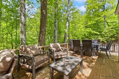 a group of chairs and tables on a deck with trees at SKYBRIDGE HILLTOP CABIN, COZY wd HOTTUB in Stanton