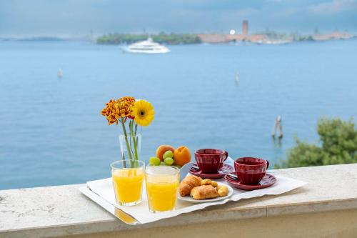 a tray of food with orange juice and fruit at Hotel Russo Palace in Venice-Lido