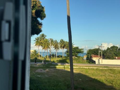 a view of the ocean and palm trees from a window at Maraki Suítes Maragogi 150M do Mar in Maragogi
