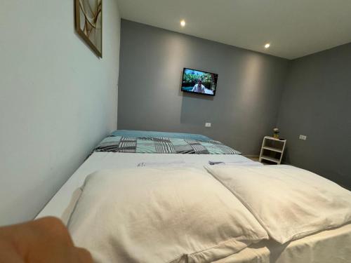 a bedroom with a bed with a tv on the wall at Maraki Suítes Maragogi 150M do Mar in Maragogi