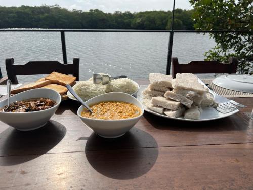 a table with bowls of food and a plate of bread at Wilpattu Nature Resort in Murandanveli