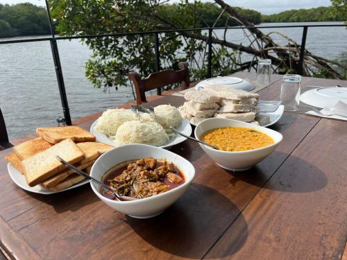a wooden table with bowls of food and bread at Wilpattu Nature Resort in Murandanveli