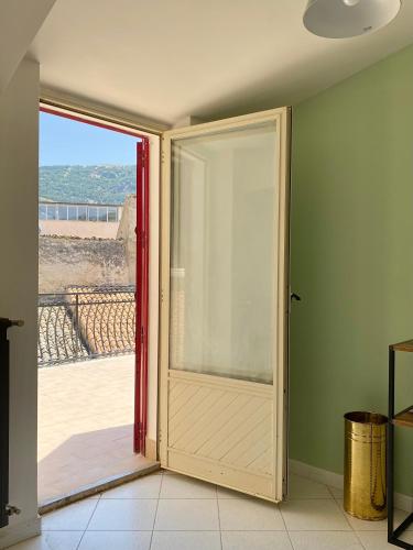 an open door with a view of a balcony at Casetta in piazza in Palazzo Adriano