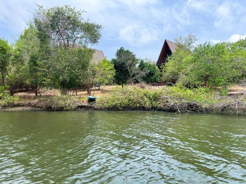 a house on the shore of a body of water at Wilpattu Nature Resort in Murandanveli