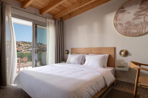 Un dormitorio con una cama grande y una ventana grande. en FOS Luxury Suites, en Nikiti
