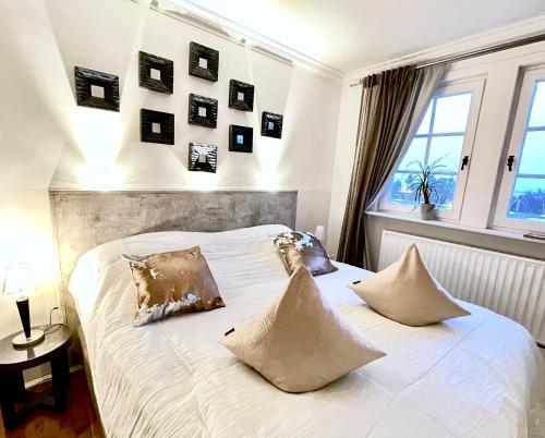 a bedroom with a white bed with pictures on the wall at VILLA ADELEes BOUTIQUE HOTEL in Alsfeld