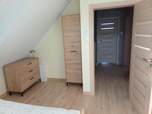 a bedroom with a bed and a dresser and a door at Willa Przygoda in Żukowo