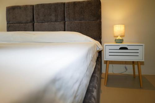a bedroom with a bed and a side table with a lamp at ELAIA Αpartments in Alexandroupoli