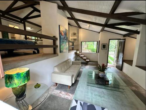 a living room with a couch and a table at Chalé em Mata Atlântica no Coração de Petrópolis in Petrópolis