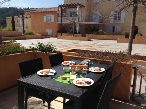 - une table noire avec de la nourriture sur la terrasse dans l'établissement Appartement dans Residence – Le Domaine de Camiole, à Callian