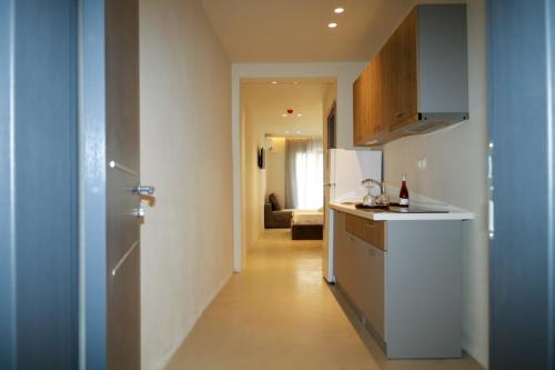 a kitchen with a white refrigerator and a hallway at ELAIA Αpartments in Alexandroupoli