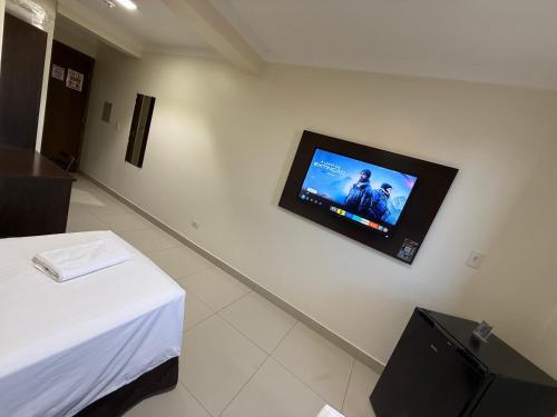 a room with a flat screen tv on the wall at Master Gold Hotel Express in Cascavel
