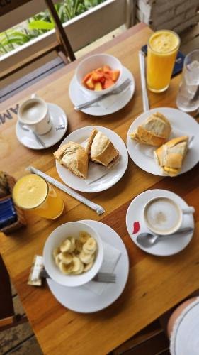 a wooden table topped with plates of food and drinks at Pousada Barra do Sahy in Barra do Sahy