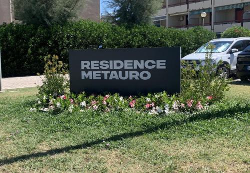 a sign for a residence metropomo in a field of flowers at Appartamento La Jolla Fano in Fano