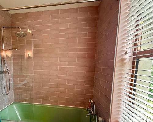 a bathroom with a green tub and a shower at Hillcrest Lodge Townhouse, Carrick-on-Shannon in Carrick on Shannon