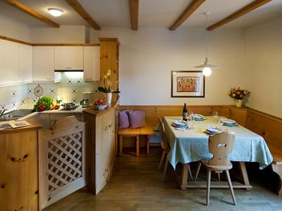 a kitchen with a table and a table and chairs at Residence Kampidell in Siusi