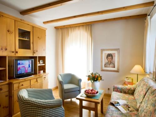 修希的住宿－Residence Kampidell，客厅配有沙发、椅子和电视