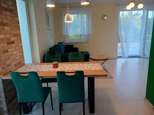 a living room with a wooden table and chairs at Willa Przygoda in Żukowo