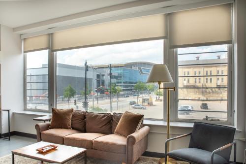 a living room with a couch and a large window at Deer District Studio Apt - One Block from Fiserv and Baird in Milwaukee