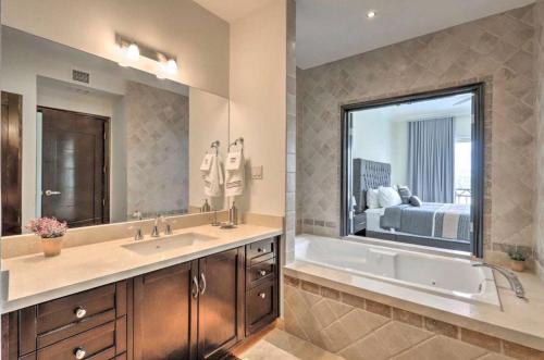 a bathroom with a tub and a large mirror at Condo de lujo Playa vista al mar Centro todo a minutos caminando in Cabo San Lucas
