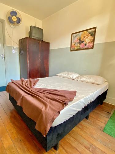 a bedroom with a bed with a blanket on it at Hotel Avenida Bauru in Bauru