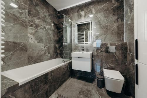 a bathroom with a white toilet and a sink at Apartamenty Jasionka Lotnisko in Rudna Mała