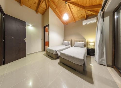 a bedroom with two beds and a large window at Eden Villas in Anafonítria