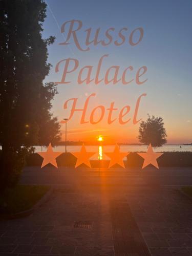 a sign that reads rissos palace hotel with the sunset at Hotel Russo Palace in Venice-Lido