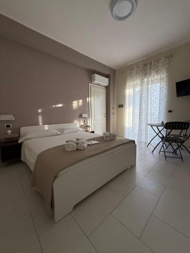 a bedroom with a large bed with towels on it at Perla Marina B&B in Nicotera Marina