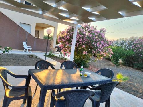 a wooden table and chairs on a patio at Casa di Cetty in Butera