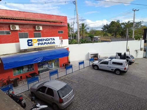 a parking lot with cars parked in front of a building at Bendita Parada - Pousada in Sobral