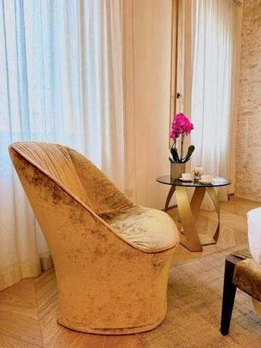 a chair in a living room with a table at Palazzo CarpeDiem-Prato della Valle in Padova