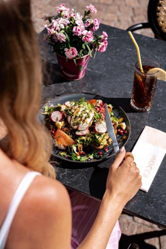 a woman sitting at a table with a plate of food at Boutique Hotel Venlo in Venlo