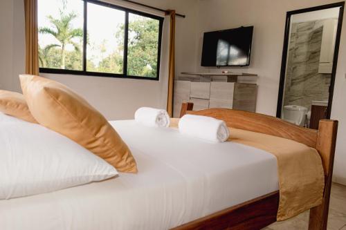 two beds in a room with a window at Hotel San Sebastian del Tonusco in Santa Fe de Antioquia